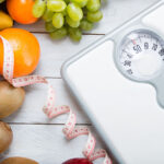 White scale with tape measure and fruit